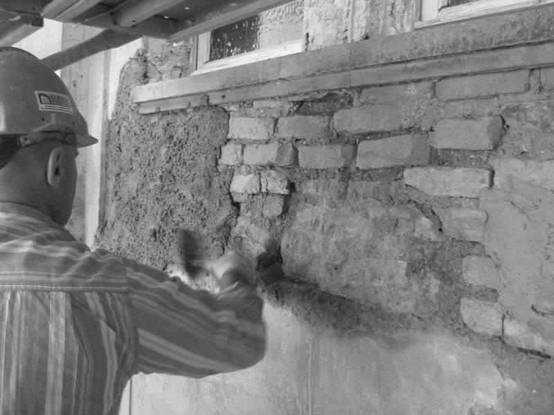 operaio esegue il risanamento di un edificio foto in bianco e nero